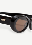 KABE SHOP INC Naomi sunglasses featuring a black oval cellulose acetate frame and brown lenses with gold logo detail