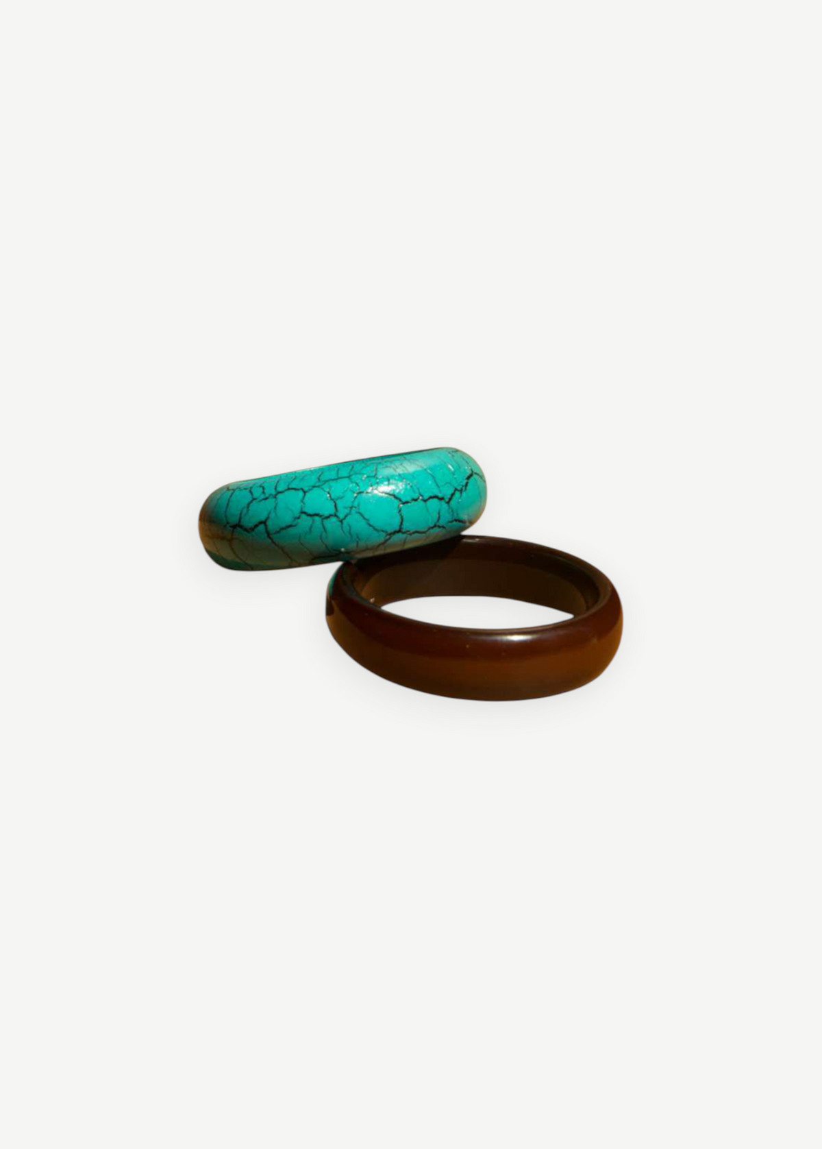 KABE SHOP INC resin bangle set featuring one turquoise crackle-patterned bracelet and one solid dark brown bracelet.