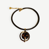 KABE SHOP INC oval pendant necklace featuring a gold-plated frame, brown cord, and a tortoiseshell-style center piece.