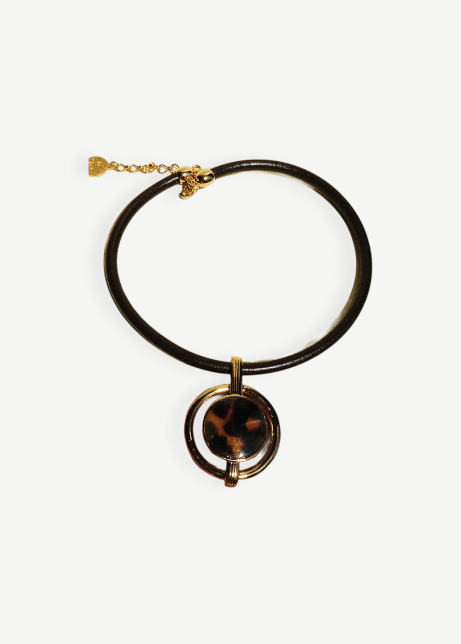 KABE SHOP INC oval pendant necklace featuring a gold-plated frame, brown cord, and a tortoiseshell-style center piece.