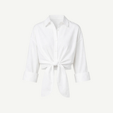 White Lisa Top featuring a collared button-down design, three-quarter length sleeves, a front tie waist, and a cropped silhouette ideal for high-waisted bottoms.