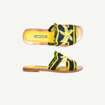 Introducing the Mazu Slide: expertly crafted sustainable open-toe sandals featuring a yellow insole, a navy blue strap adorned with green fringed trim, and a striking yellow and white hand-embroidered starfish design on the upper strap—perfect for making an eco-conscious style statement.