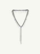 The Lariat Necklace White Bronze is a V-shaped lariat necklace in a sleek silver tone, featuring an adjustable length and long cascading chains draping from the center like a metallic ribbon, shown against a plain white background.