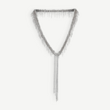 The Lariat Necklace White Bronze is a V-shaped lariat necklace in a sleek silver tone, featuring an adjustable length and long cascading chains draping from the center like a metallic ribbon, shown against a plain white background.