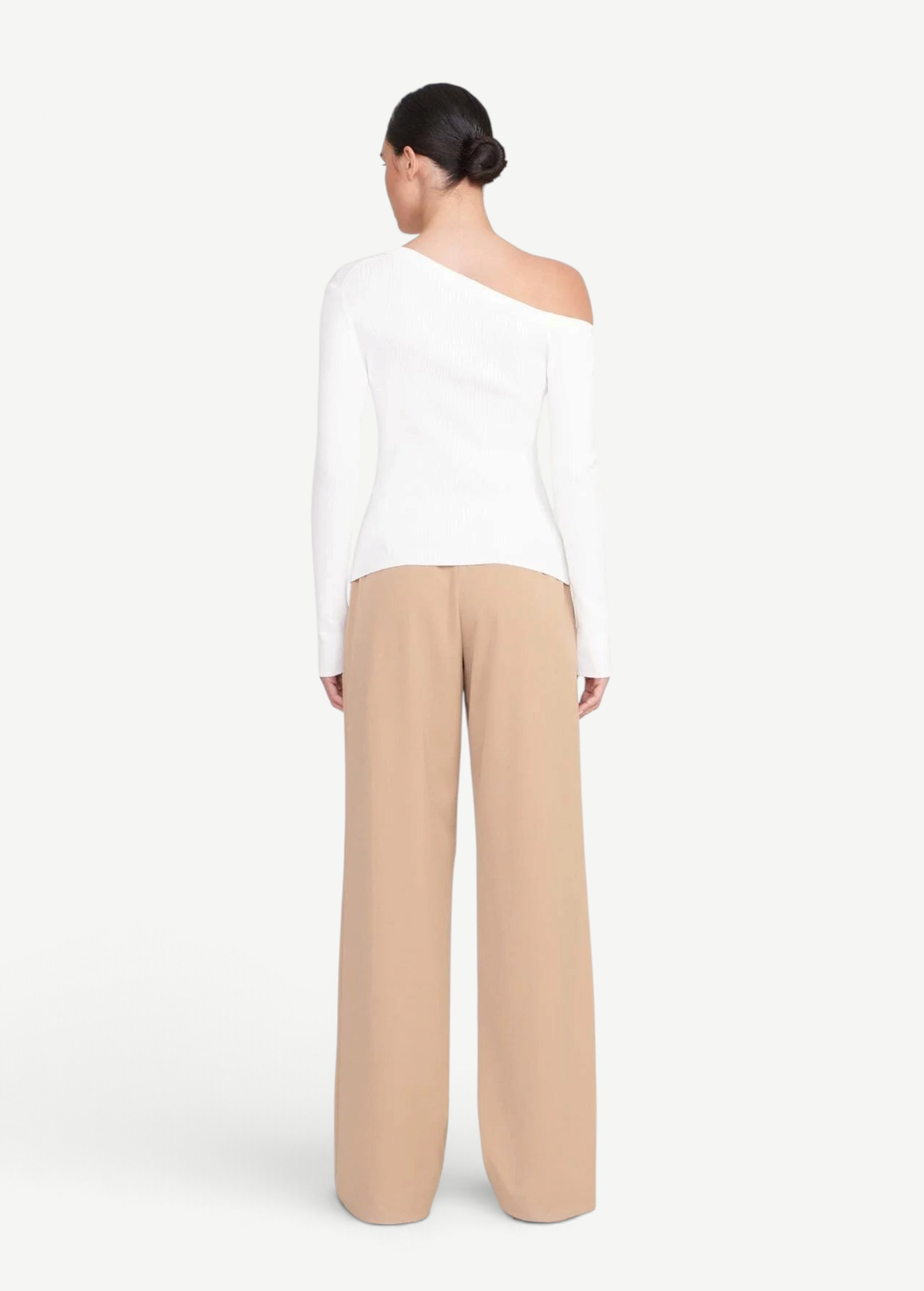 Back view of a woman wearing a white KABE SHOP INC Craftsman Sweater with an asymmetrical off-shoulder neckline.