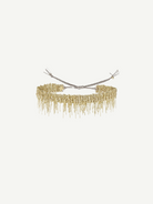 A gold beaded choker necklace with fringed dangling strands, tied at the back with adjustable silver cords, is beautifully displayed against a plain white background—an ideal match for the N° 675 Gold Bracelet, creating an elegant layered look.