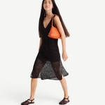 KABE SHOP INC Rosanna Bag in orange handwoven buffalo leather worn over the shoulder by a model in a black dress