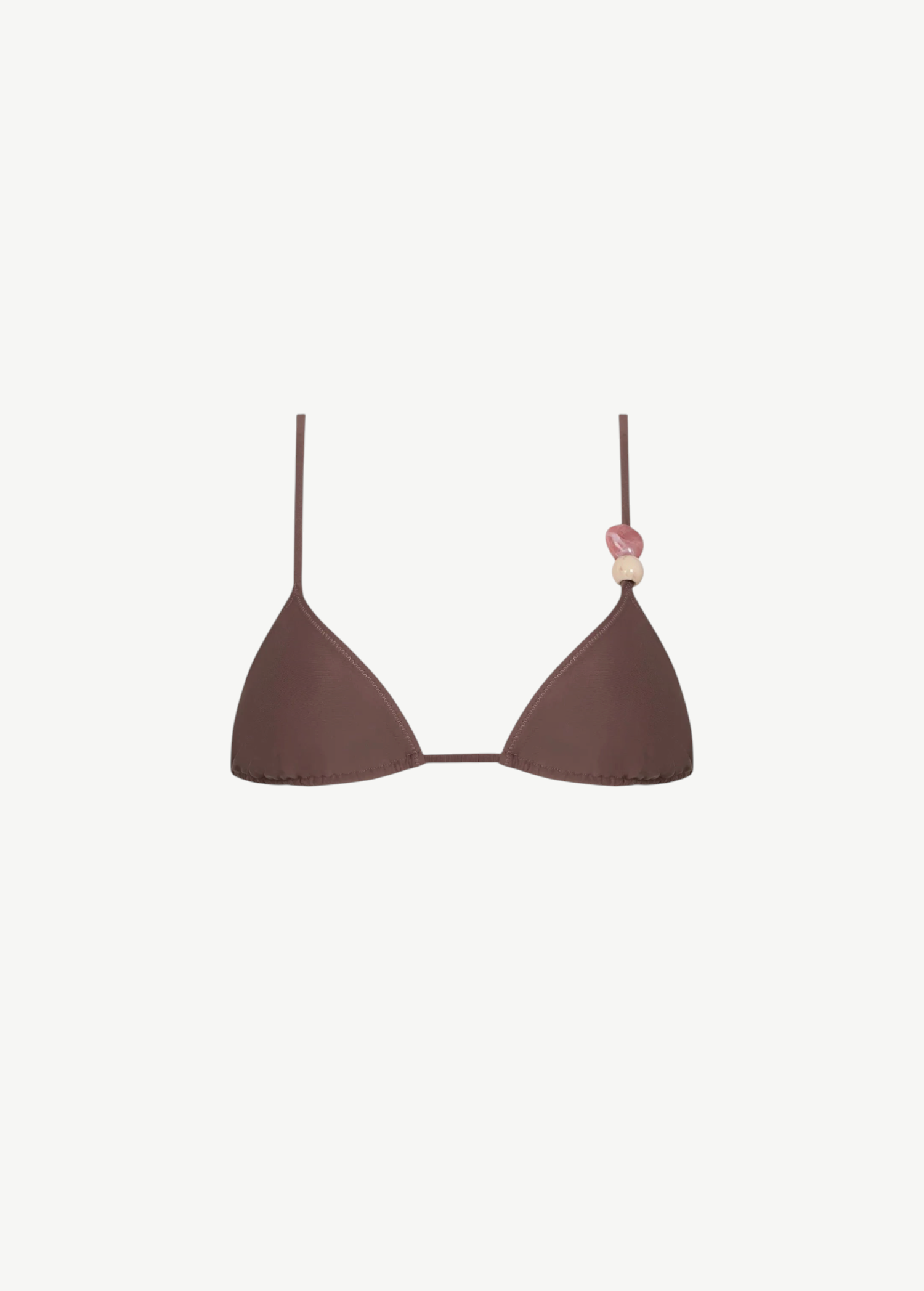 Introducing the Equator Top: an eco-friendly brown triangle bikini top featuring thin, adjustable straps. The left strap is adorned with three decorative beads in pink and beige tones, blending stylish design with sustainable swimwear choices.