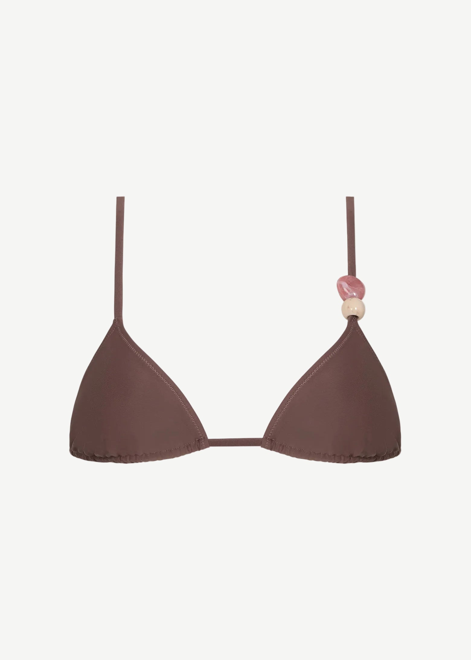 Introducing the Equator Top: an eco-friendly brown triangle bikini top featuring thin, adjustable straps. The left strap is adorned with three decorative beads in pink and beige tones, blending stylish design with sustainable swimwear choices.