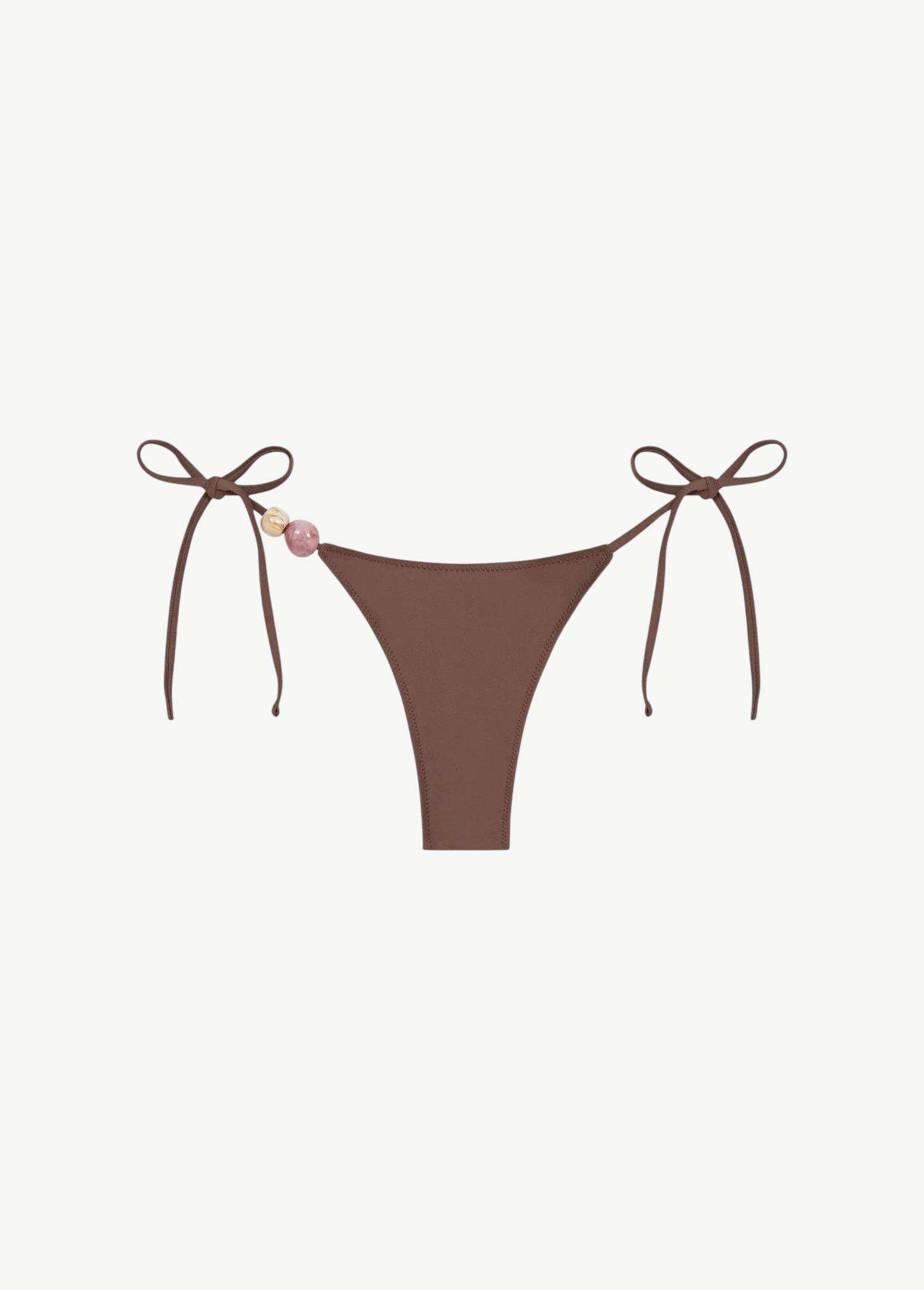 Praia Bottom in brown with adjustable tie sides, adorned with a pink and a beige bead on the left string, crafted from recycled polyamide for an eco-friendly swimwear option, shown on a white background.