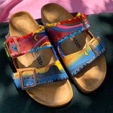 KABE SHOP INC hand-painted and embroidered Birkenstocks with vibrant rainbow, mountain, and floral designs.
