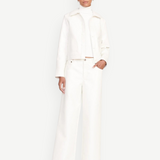 Model wearing KABE SHOP INC Grayson wide-leg white pants with a matching white jacket and turtleneck