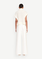Back view of a model wearing KABE SHOP INC white wide-leg Grayson pants paired with a cream textured knit top