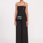 Model wearing a KABE SHOP INC Lennon convertible black bag as a crossbody accessory with a matching black jumpsuit.