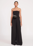 Model wearing a KABE SHOP INC Lennon convertible black bag as a waist belt with a matching black strapless jumpsuit
