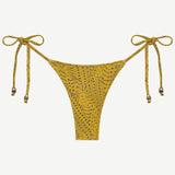 The Praia Bottom is a yellow bikini bottom with a subtle dotted pattern and adjustable side ties, each embellished with small decorative beads. Designed as eco-friendly swimwear, this piece is shown against a plain white background.