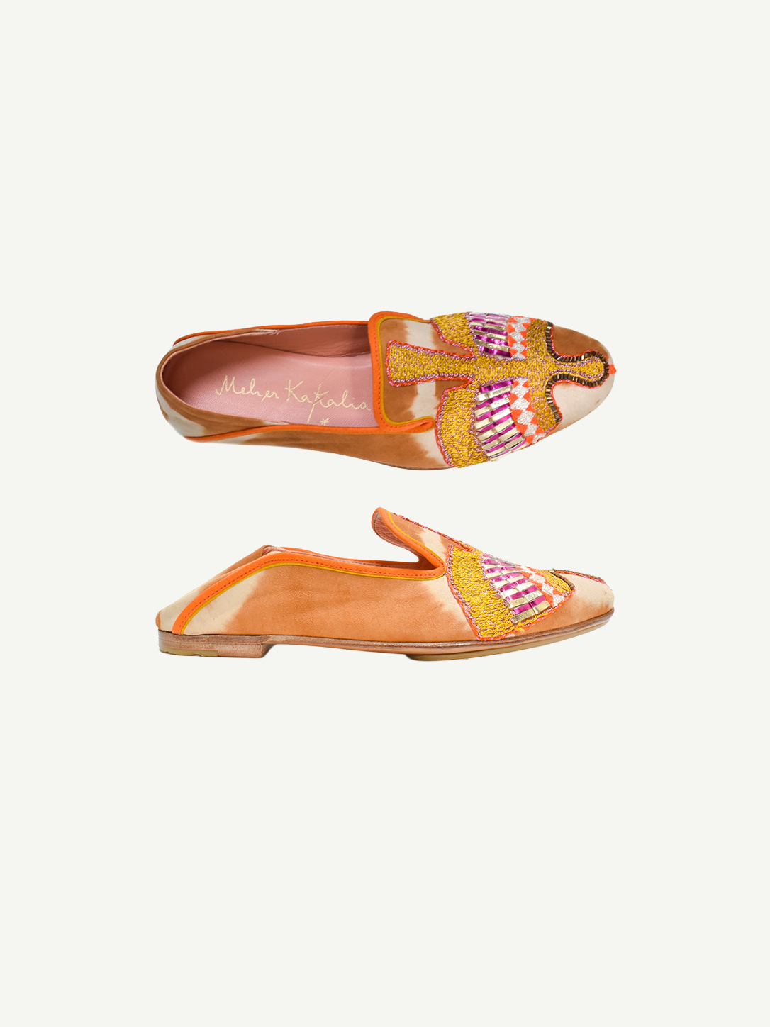 Two orange Anzu Moccasins featuring intricate pink, yellow, and gold beaded embroidery on the uppers are displayed side by side on a white background. These hand-embroidered moccasins showcase artful craftsmanship and style, making them a unique statement piece.