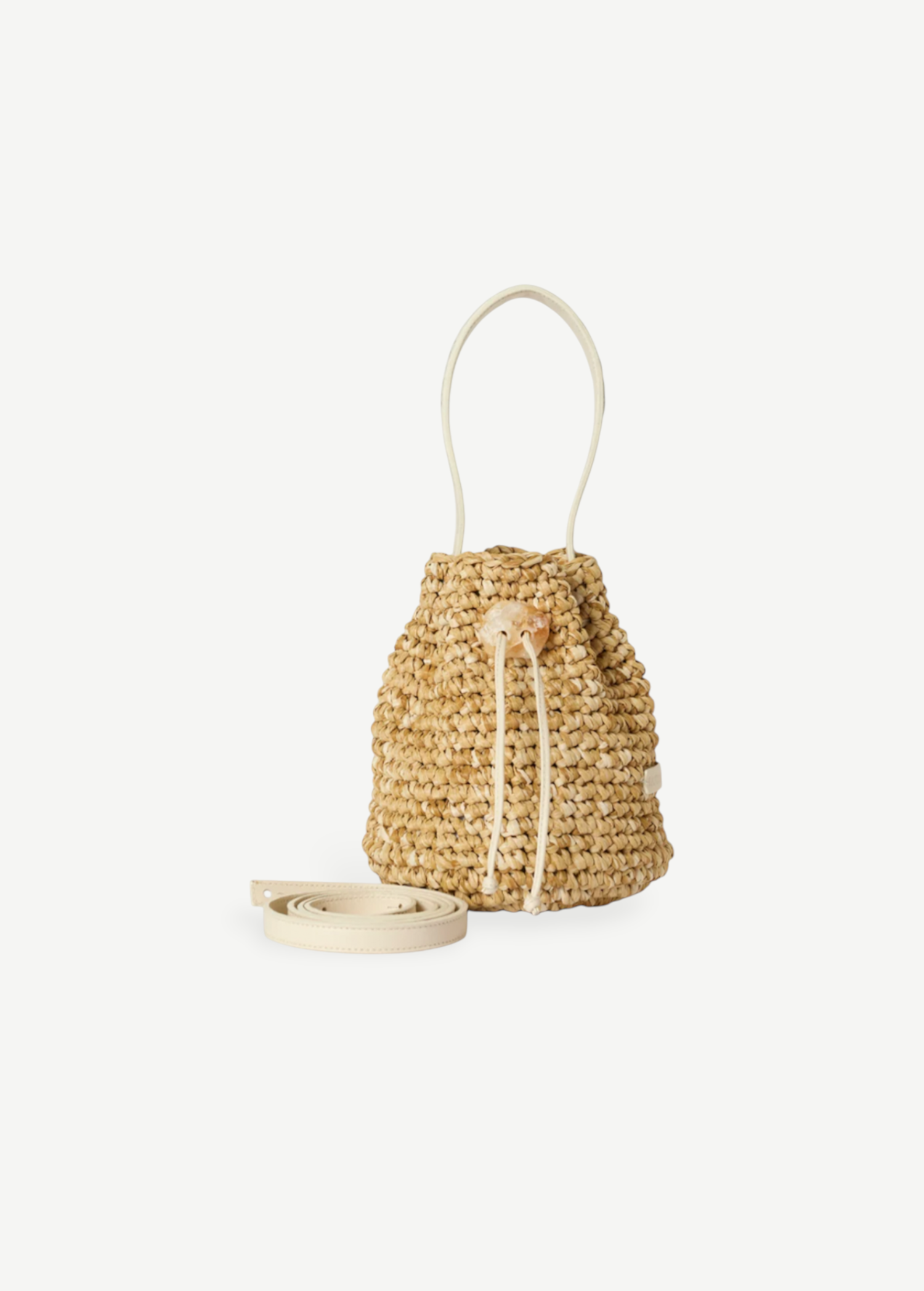 KABE SHOP INC Nirmala bucket bag in woven raffia with white leather trim and a unique crystal drawstring closure.