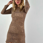 Model wearing a KABE SHOP INC long-sleeve brown crochet mini dress with intricate handwoven patterns and a fedora hat.
