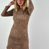 Model wearing a KABE SHOP INC long-sleeve brown crochet mini dress with intricate handwoven patterns and a fedora hat.