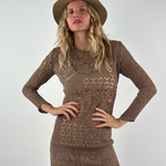 Model wearing a KABE SHOP INC long-sleeve brown crochet mini dress and a matching fedora hat against a white wall.