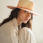 KABE SHOP INC Awisqa hat featuring a woven straw design in soft peach and beige tones with a delicate cord detail.