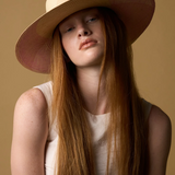 KABE SHOP INC Awisqa hat featuring a natural straw crown and wide pink brim worn by a model with long red hair