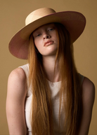 KABE SHOP INC Awisqa hat featuring a natural straw crown and wide pink brim worn by a model with long red hair