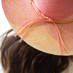 KABE SHOP INC Awisqa hat in pink and natural straw with a delicate knotted cord detail worn by a woman