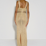Model wearing a beige KABE SHOP INC crochet maxi dress with a halter neckline and back slit, viewed from behind.