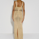 Model wearing a beige KABE SHOP INC crochet maxi dress with a halter neckline and back slit, viewed from behind.