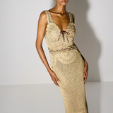 Model wearing a KABE SHOP INC beige crochet maxi dress with a lace-up bodice and fitted silhouette.