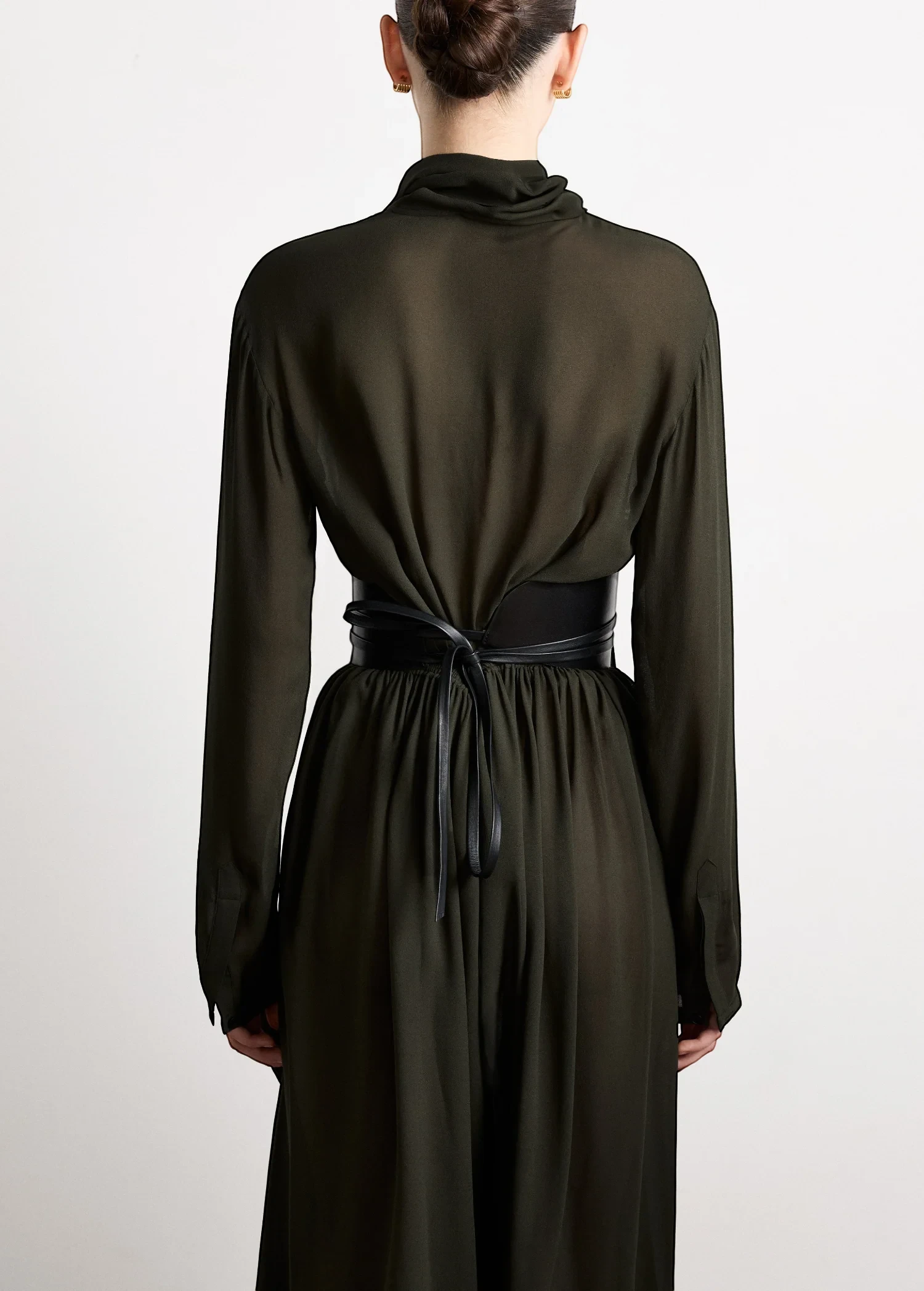 KABE SHOP INC Undone Corset Belt in black calfskin worn over a dark green dress, showing back view and tie detail.