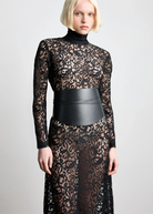 KABE SHOP INC Undone Corset Belt in black calfskin worn over a sheer black lace dress for a sculpted waist silhouette