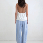 Model wearing KABE SHOP INC Breezy Pant, a light blue straight-leg trouser with a relaxed fit, back view.