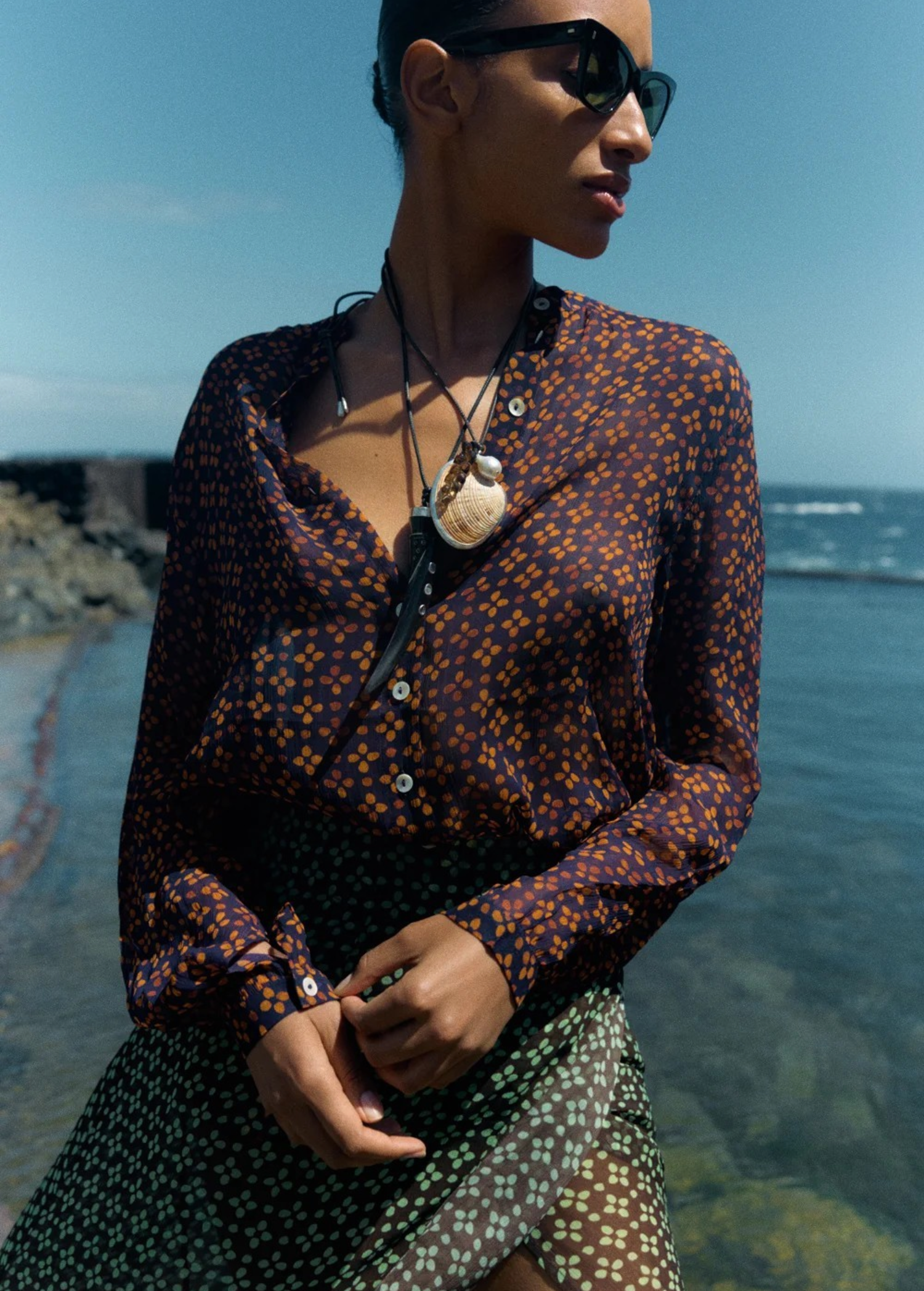 KABE SHOP INC butterfly shell necklace with whiskey quartz and baroque pearl on leather cord worn by a model