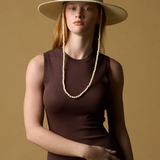 Model wearing a KABE SHOP INC Cajas wide brim straw hat with beaded chin strap against a tan background.