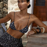 Model wearing KABE SHOP INC Calypso triangle bikini top in black and white abstract print with wooden bead accents