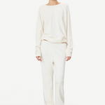 Model wearing KABE SHOP INC ÉTERNE cream French terry sweatpants and matching long-sleeve top in a relaxed fit.