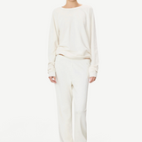 Model wearing KABE SHOP INC ÉTERNE cream French terry sweatpants and matching long-sleeve top in a relaxed fit.