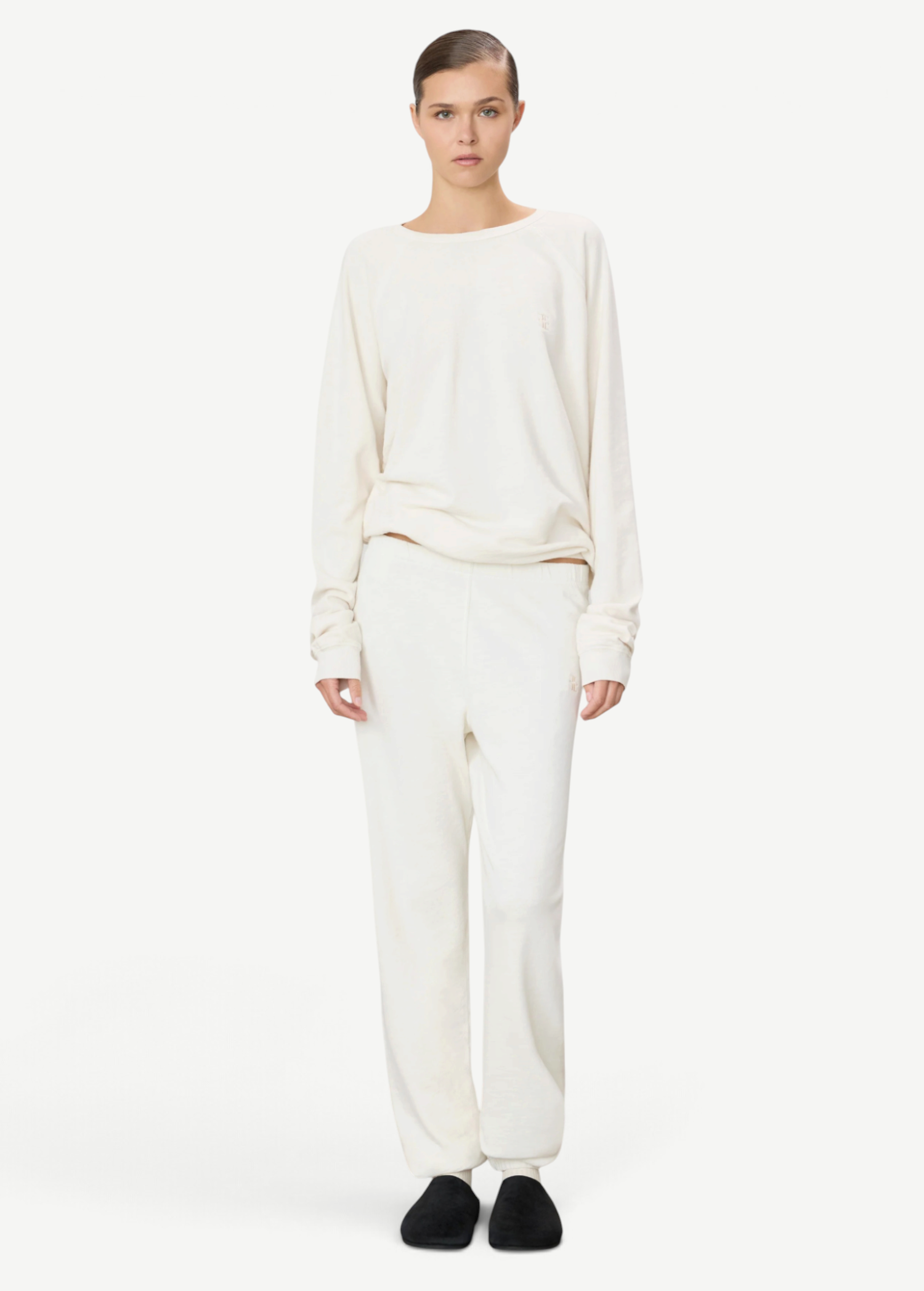 Model wearing KABE SHOP INC ÉTERNE cream French terry sweatpants and matching long-sleeve top in a relaxed fit.