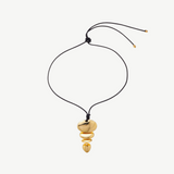 KABE SHOP INC gold sculptural pendant necklace with an adjustable black cord and stacked metallic shapes