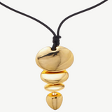 KABE SHOP INC gold sculptural pendant necklace on a black cord, featuring a tiered organic shape design.