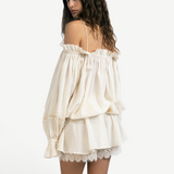 Model wearing a KABE SHOP INC Isabella jumpsuit in cream cotton with off-the-shoulder sleeves and delicate lace trim.