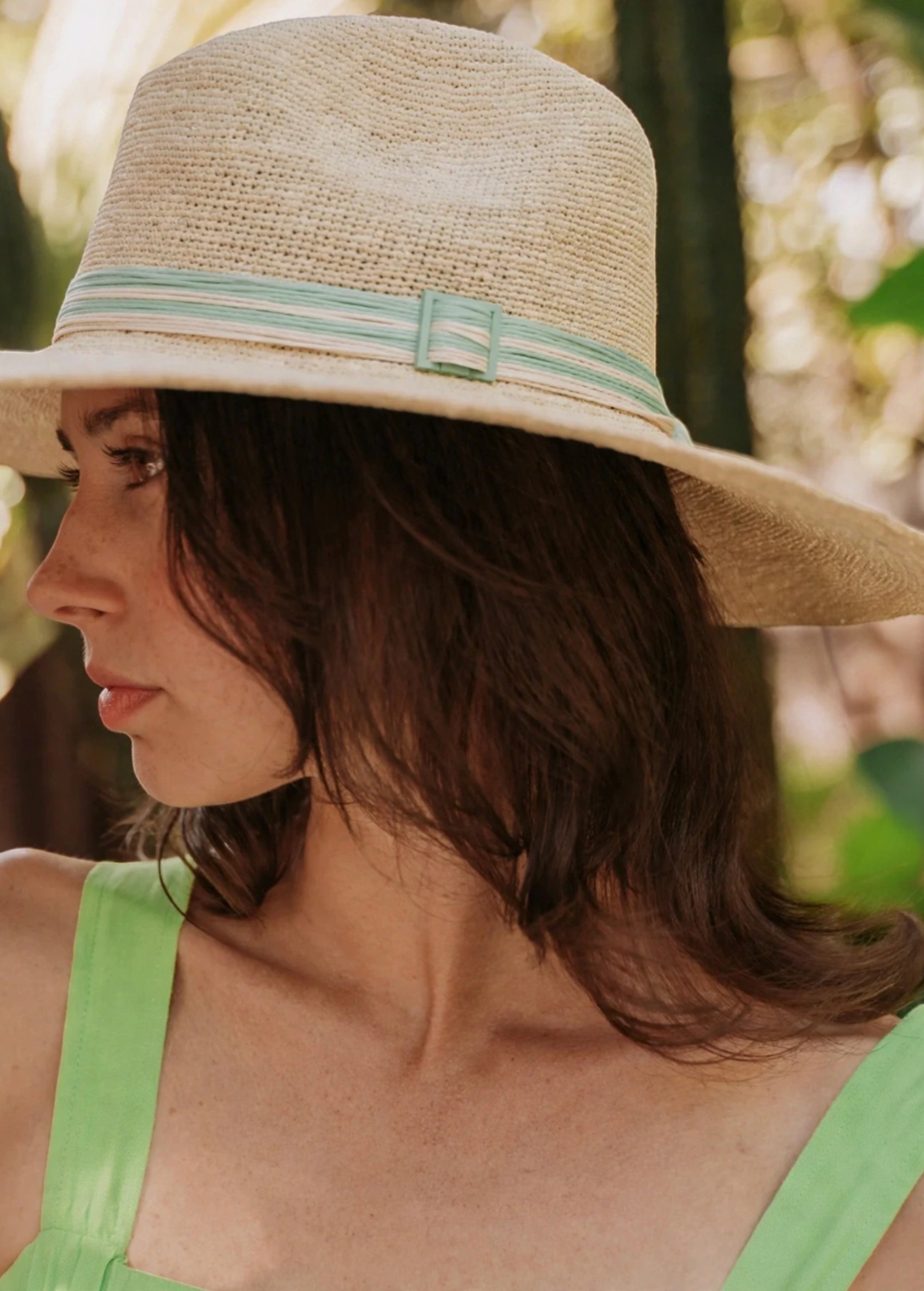 KABE SHOP INC Isabella wide brim straw hat with a striped ribbon detail worn by a woman in a sunny outdoor setting