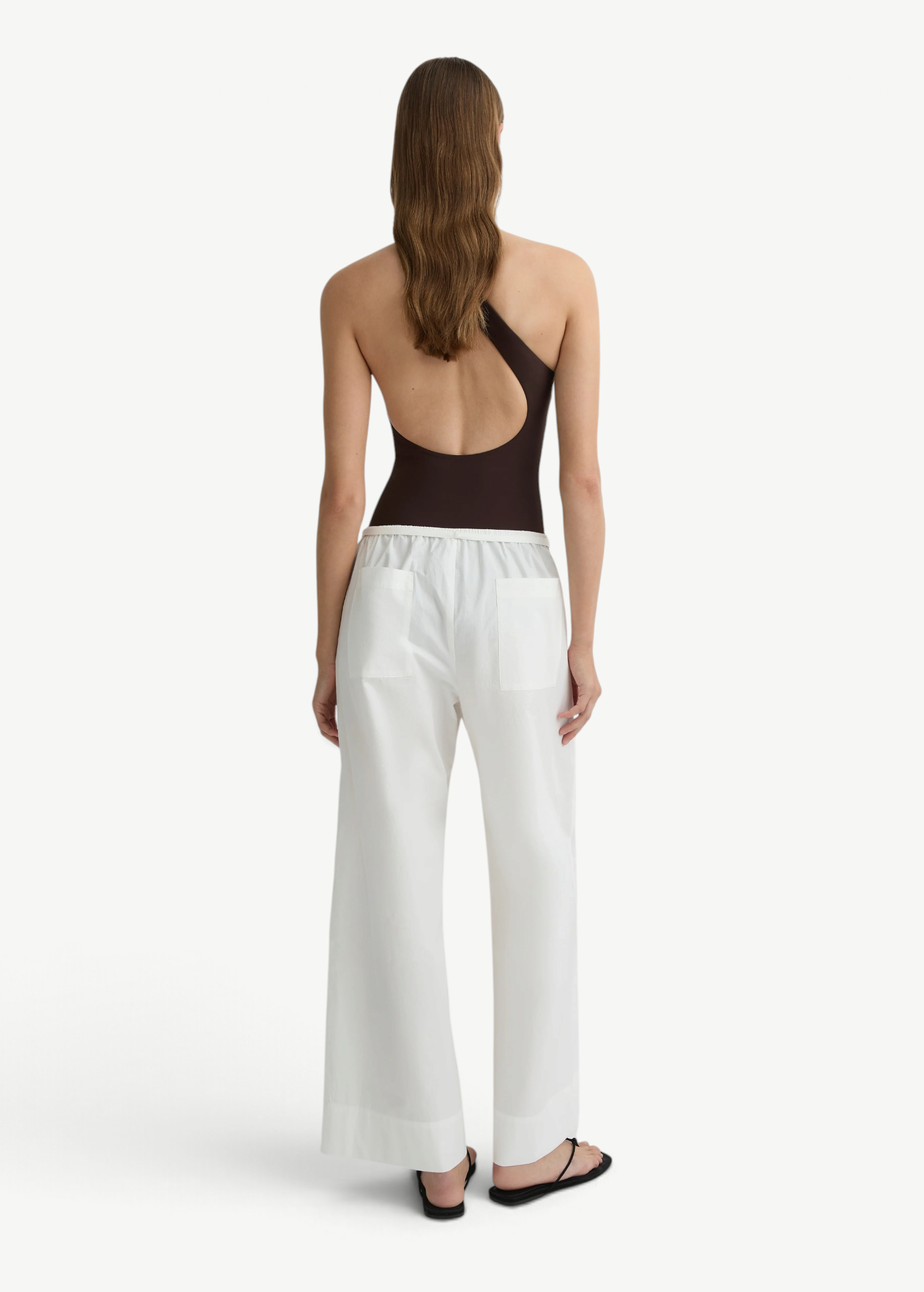 KABE SHOP INC Kyoto white wide leg cotton pants worn by a model from the back view with a dark brown bodysuit.