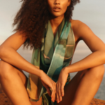 KABE SHOP INC Magdalena Pareo with a fluid landscape print worn as a halter top by a woman at sunset