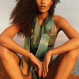 KABE SHOP INC Magdalena Pareo with a fluid landscape print worn as a halter top by a woman at sunset