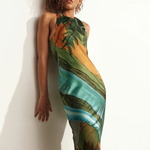 Model wearing KABE SHOP INC Magdalena long silk maxi dress with halter neckline and landscape print