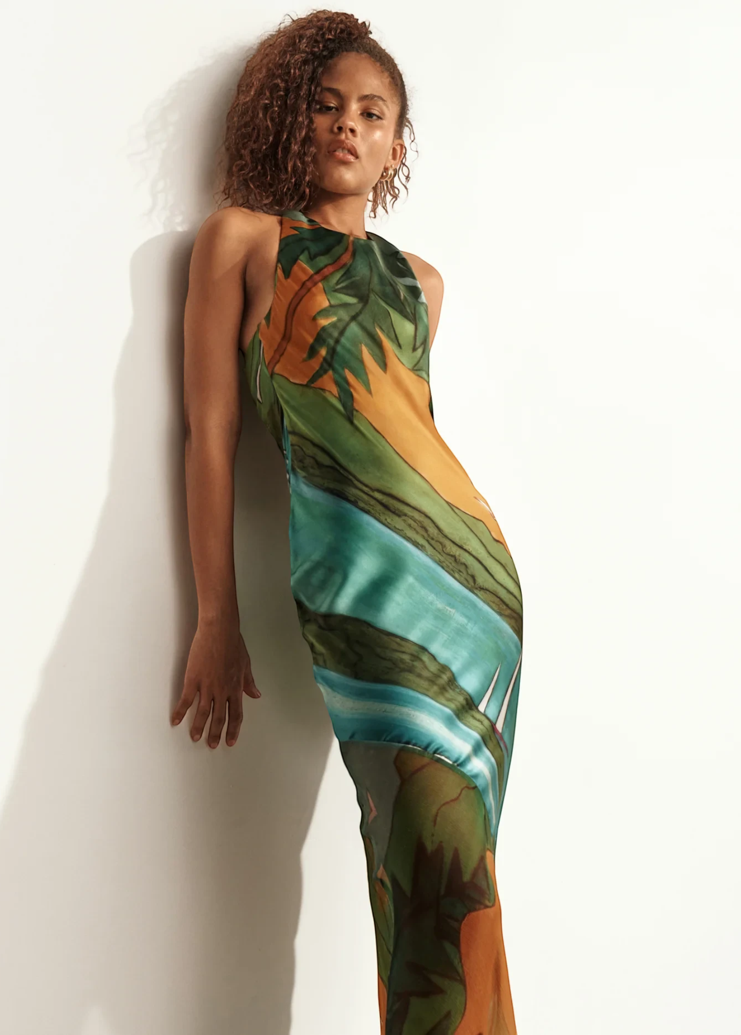 Model wearing KABE SHOP INC Magdalena long silk maxi dress with halter neckline and landscape print